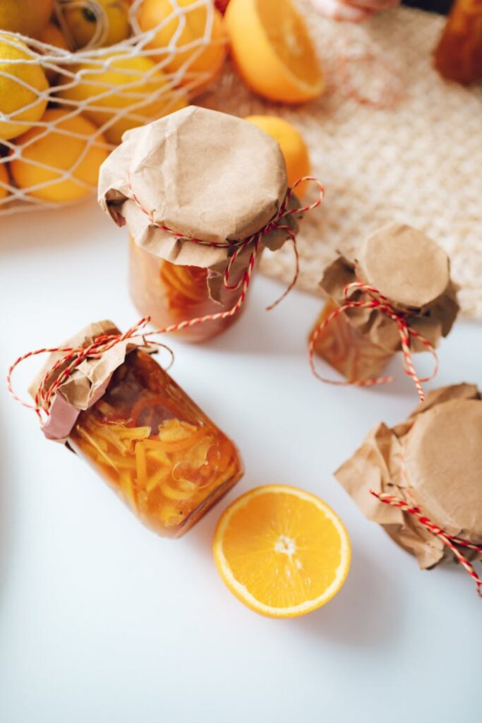 Top view of homemade orange preserves in jars, beautifully wrapped with rustic paper and twine.